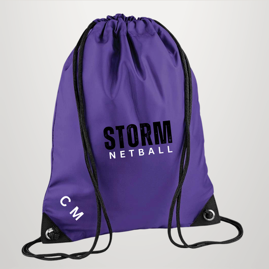 A purple drawstring backpack with black zippers and cords, featuring 'STORM NETBALL' printed in black and white on the front, and 'CM' in white near the bottom left corner.