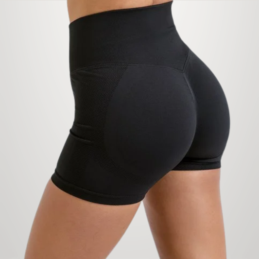 Black high-waisted compression shorts shown on a model from a side-rear angle against a light gray studio background.