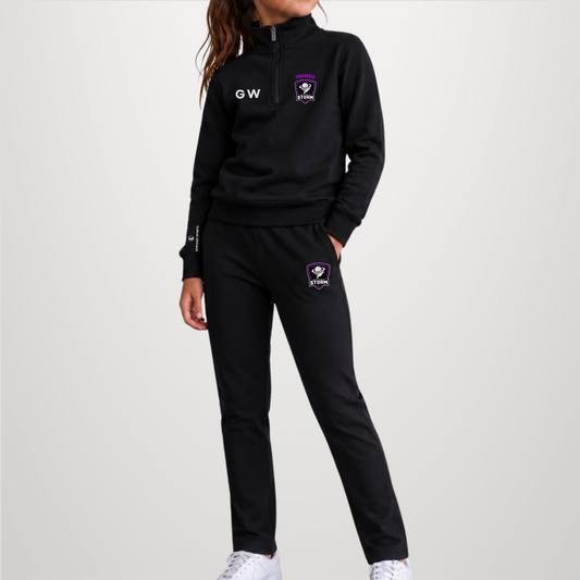 A model wearing a black athletic tracksuit with a half-zip hoodie and matching joggers. The hoodie features a purple and white shield logo on the left chest and a white 'GW' monogram on the right chest.