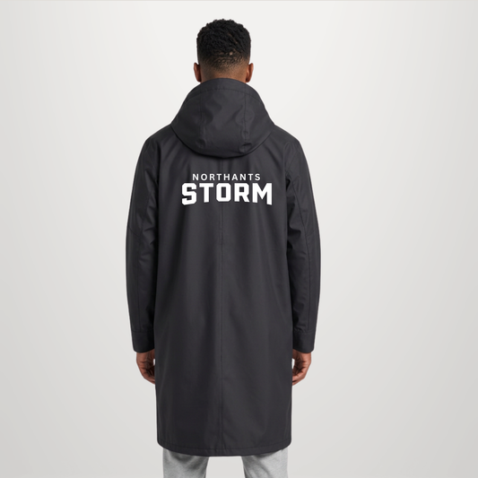 A man viewed from behind wearing a dark gray hooded jacket with 'NORTHANTS STORM' printed in bold white letters on the back, set against a plain light gray studio background.